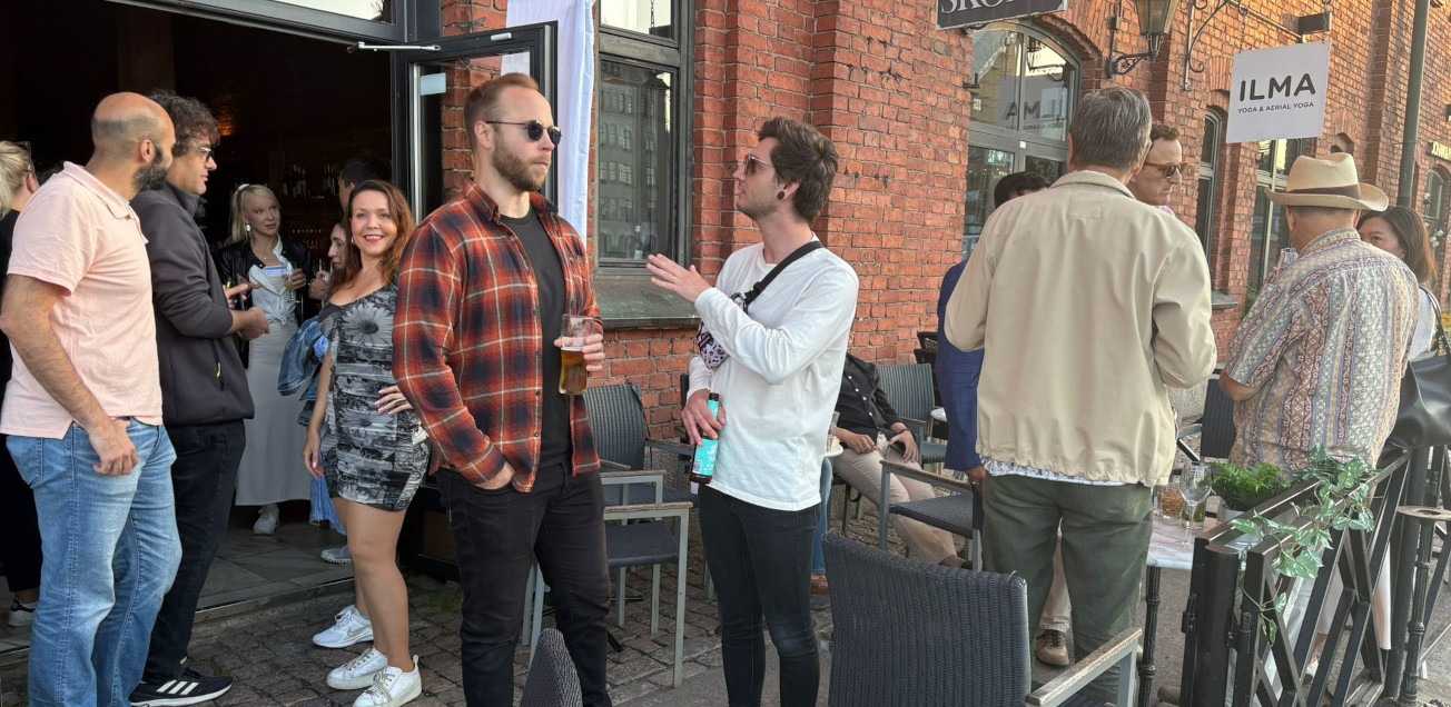 Attendees of the Helsinki August Summer Social mingling on the venue's terrace.